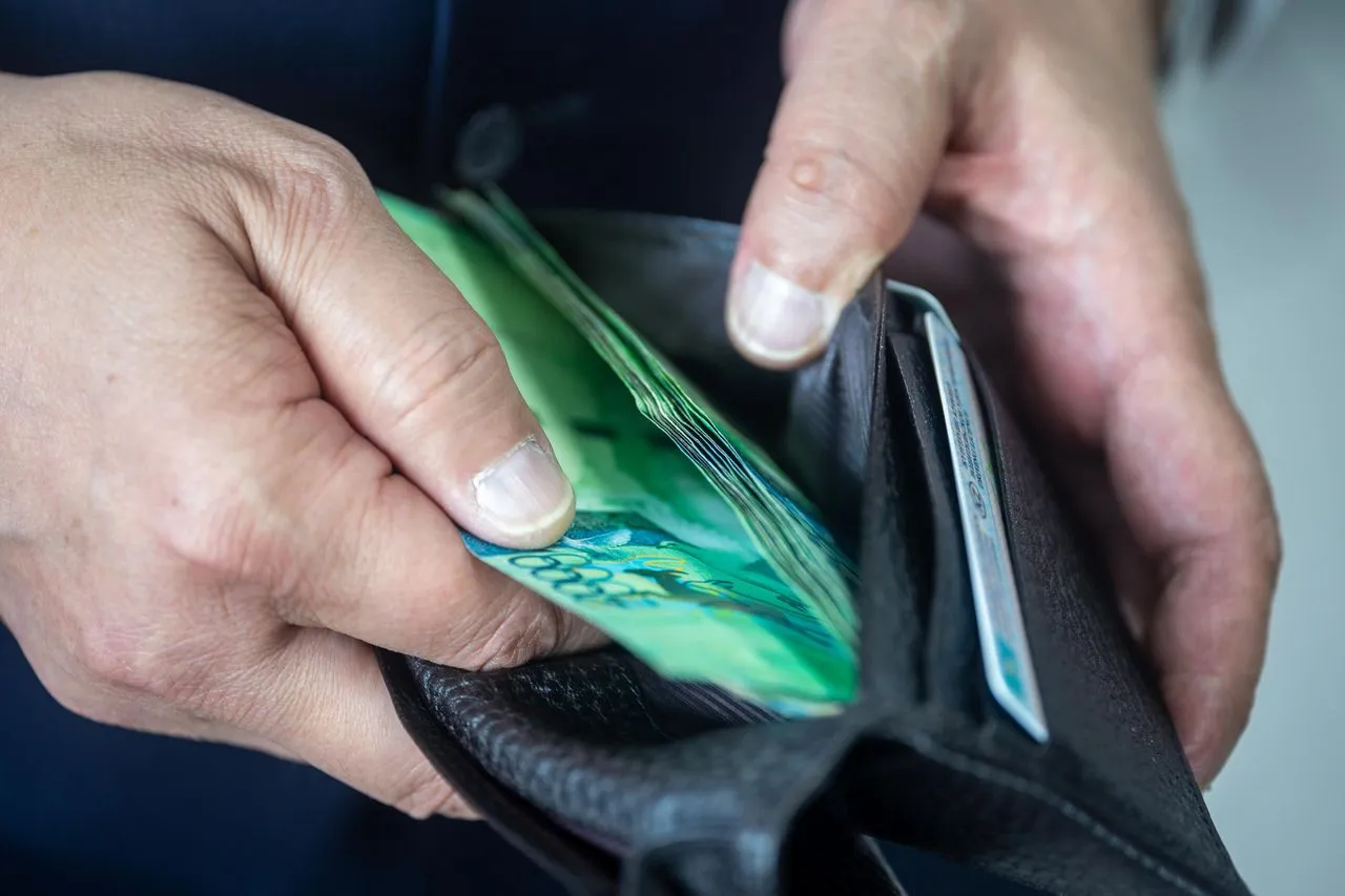 Un homme sur le point de payer, illustrant les dépenses qu'implique l'adoption d'un chien.